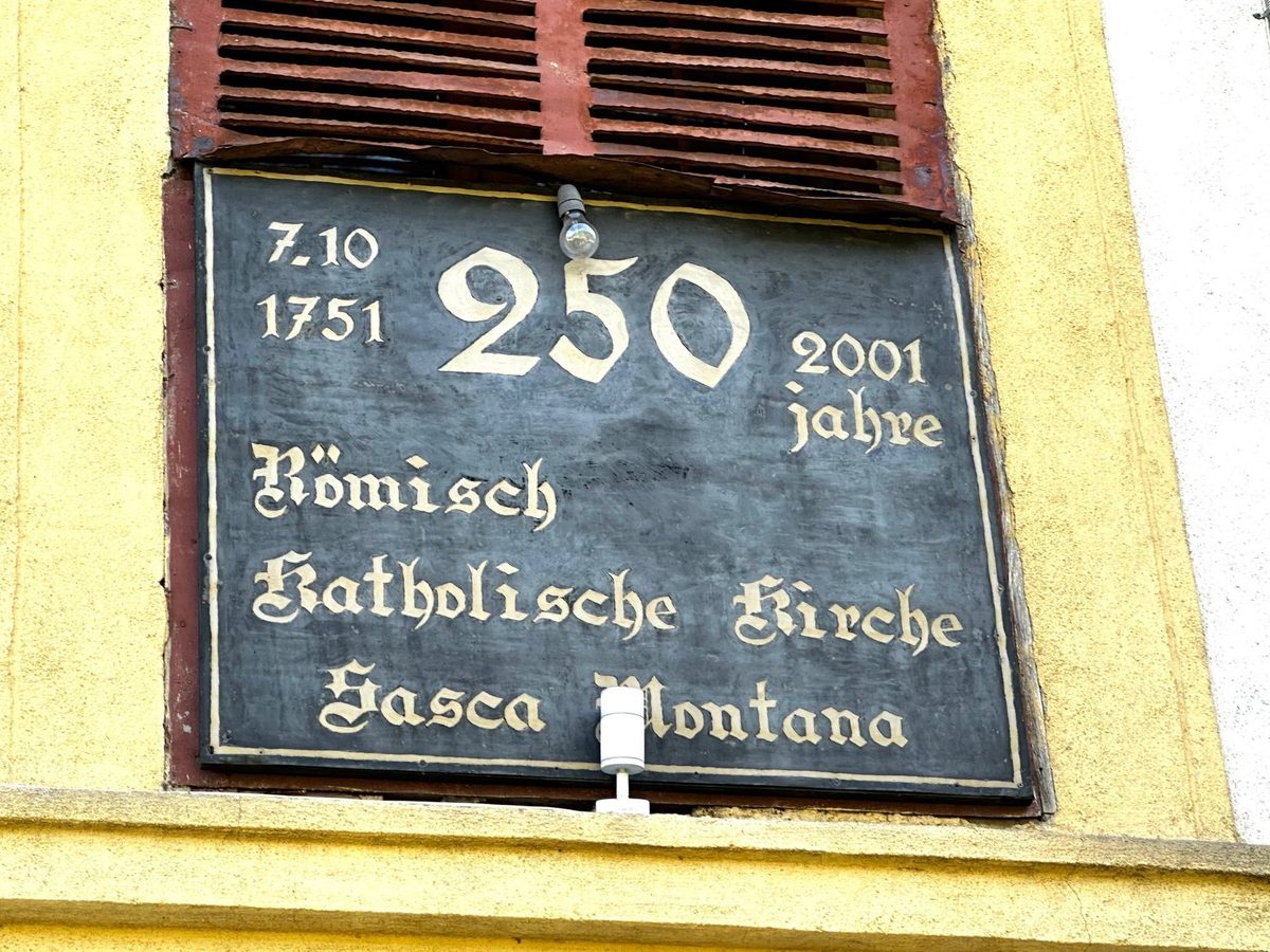Placa în litere gotice de pe fațada bisericii romano-catolice, cu data de 7 octombrie 1751 și cei 250 de ani împliniți în 2001