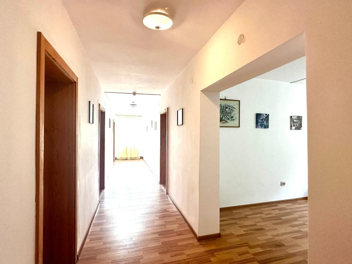 Holul de la etaj, cu uși de lemn de o parte și de alta și gravuri înrămate pe perete