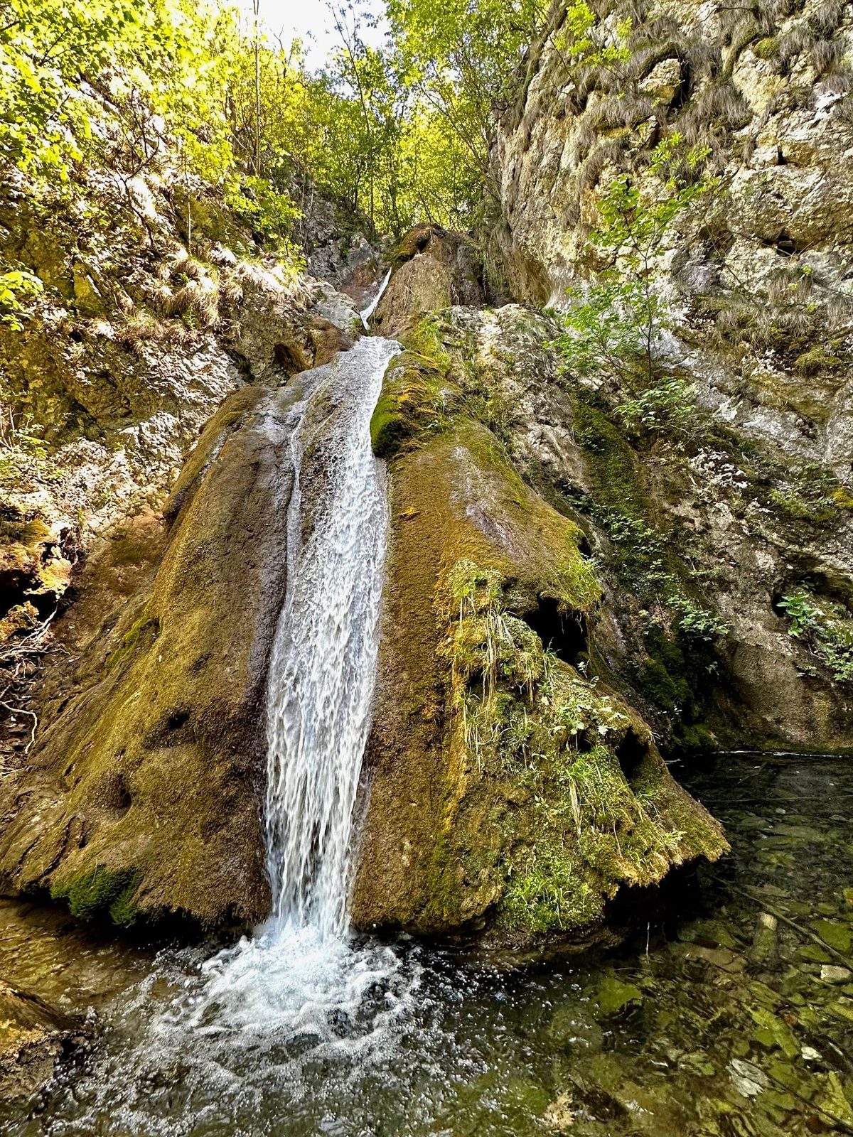 Cascada Șușara și lacul de sub ea, cu pereții de calcar ai cheilor de o parte și de alta